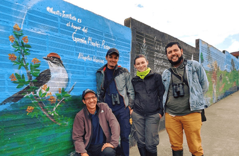 Rodolfo Correa Peña (far right), Sergio Chaparro-Herrera (middle left), Andrea Lopera-Salazar (middle right), and Juan L. Parra (far left) rediscovered the Antioquia Brushfinch. They are standing next to a mural of this species in San Pedro de los Milagros. Photo credit: Andrea Lopera-Salazar