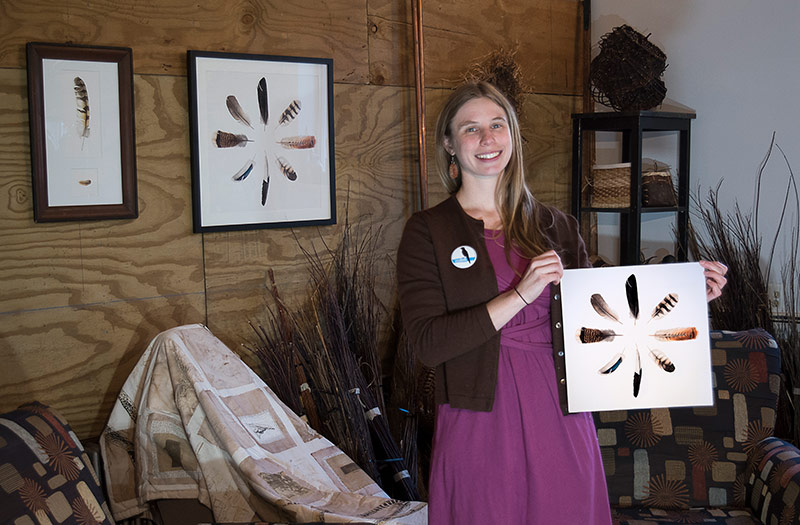 Katie with prints of her watercolor feather art